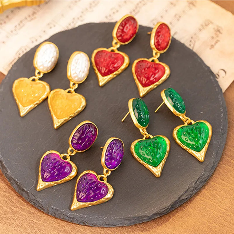 A pair of pleated oval love heart stud earrings in alloy, showing the silver needle post.