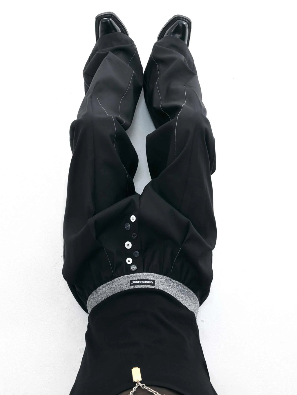 Men's grey straight-leg high-waisted trousers with a button-fly opening on a neutral background.