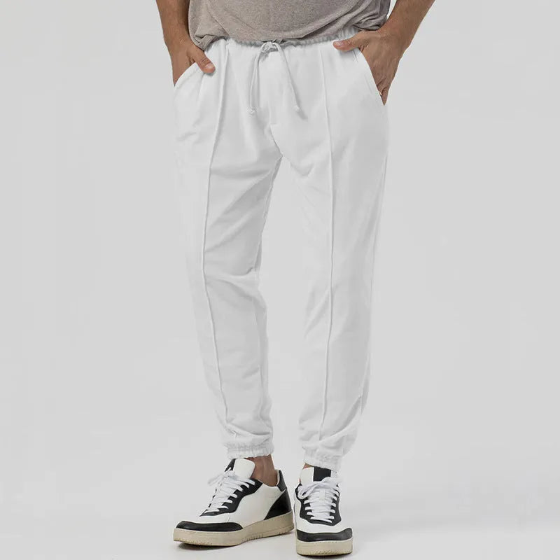 Men's grey loose-fit tapered track sweatpants with a straight leg on a neutral background.