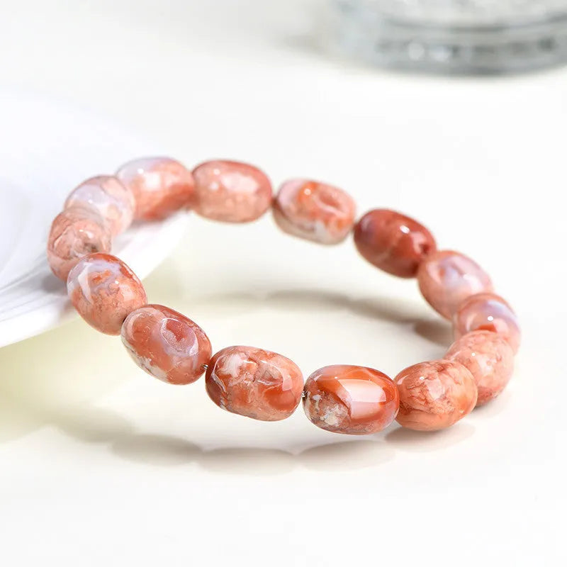 Natural cherry agate bracelet with barrel-shaped beads showing geometric design and Ruyi patterns