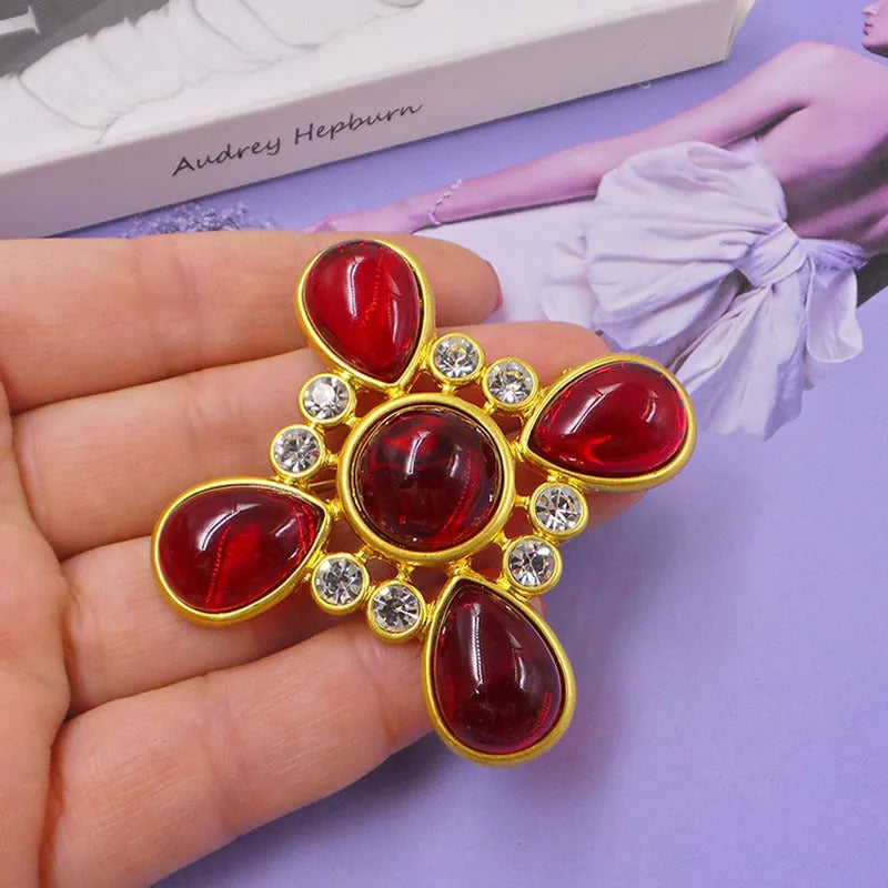 Close-up of vintage medieval baroque cross brooch with crystal details on zinc alloy base