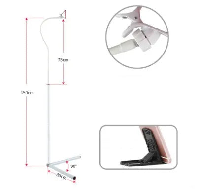 Black bedside phone holder with universal mobile phone bracket and adjustable overhead support shelf positioned next to bed