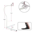 Black bedside phone holder with universal mobile phone bracket and adjustable overhead support shelf positioned next to bed