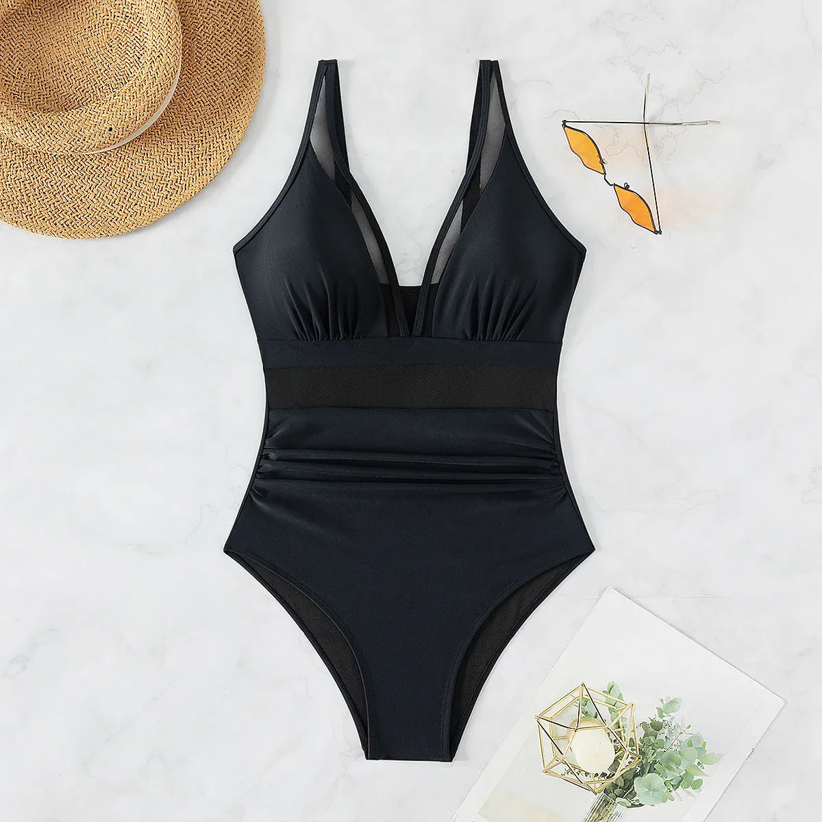 Black halter neck one-piece swimsuit with mesh detail, shown on model.