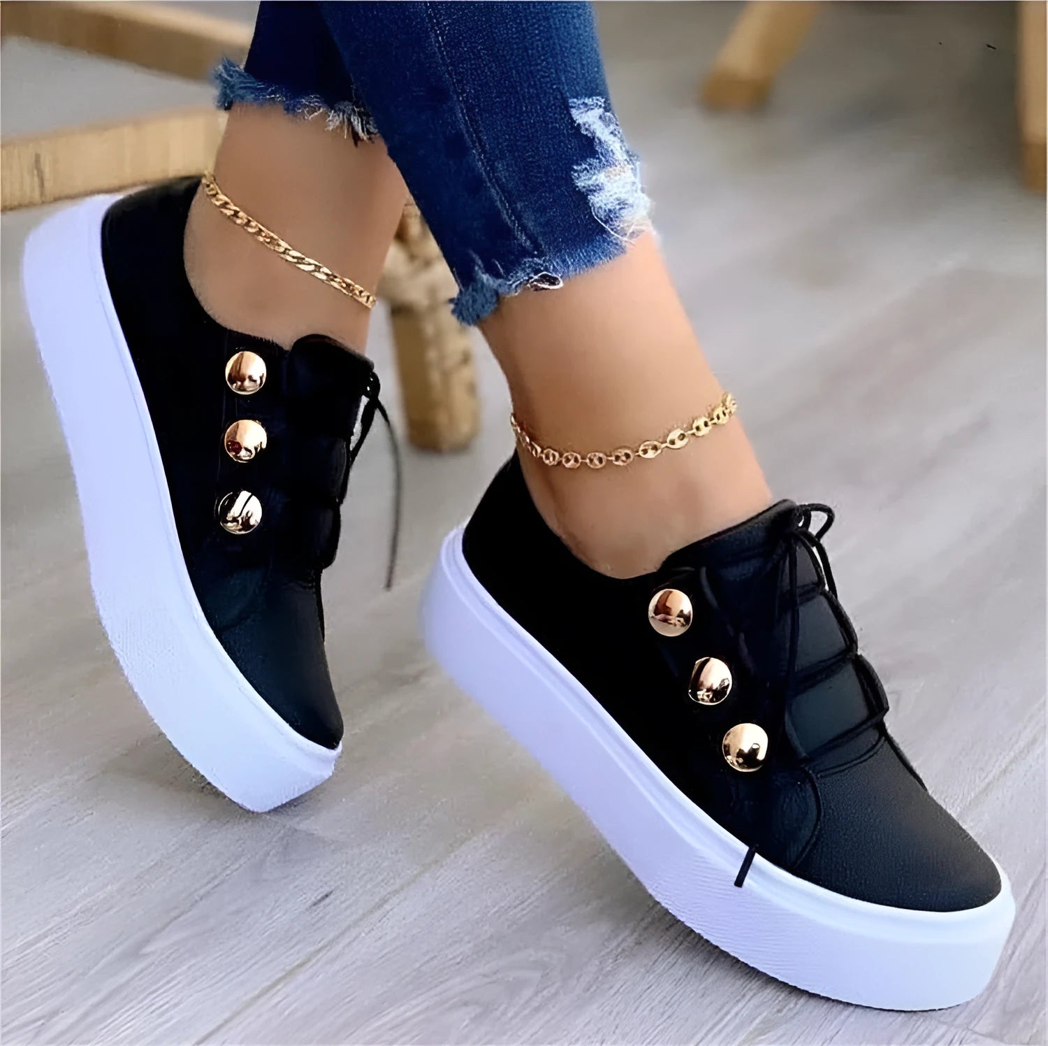 Women's white lace-up flat sneakers with silver rivet detailing on a round toe.