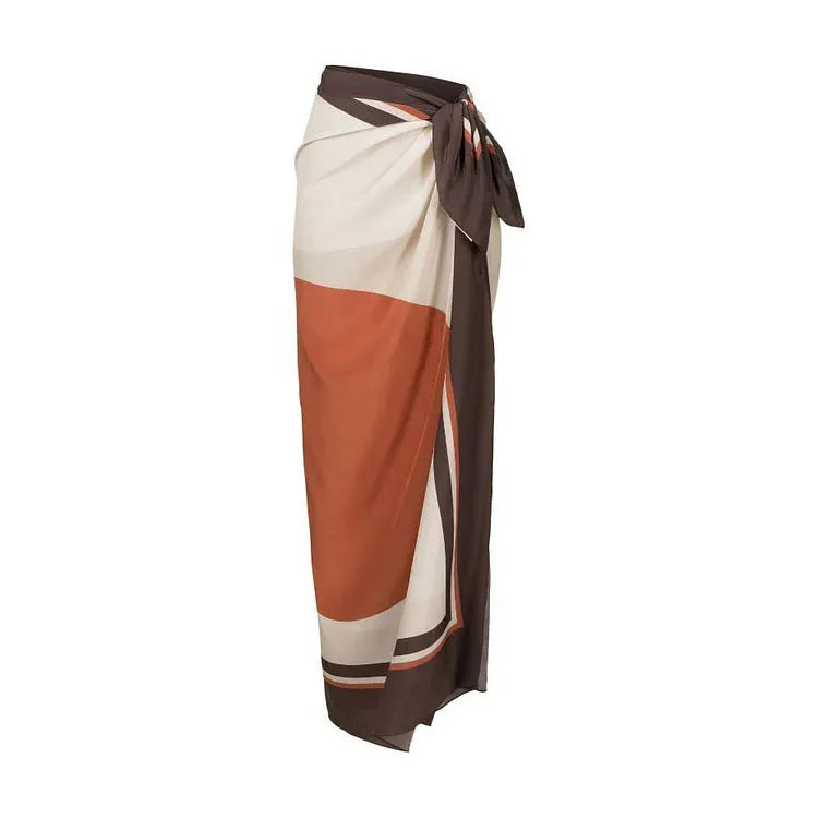 Women's printed dot pattern one-piece swimsuit with matching wrap skirt on a hanger.