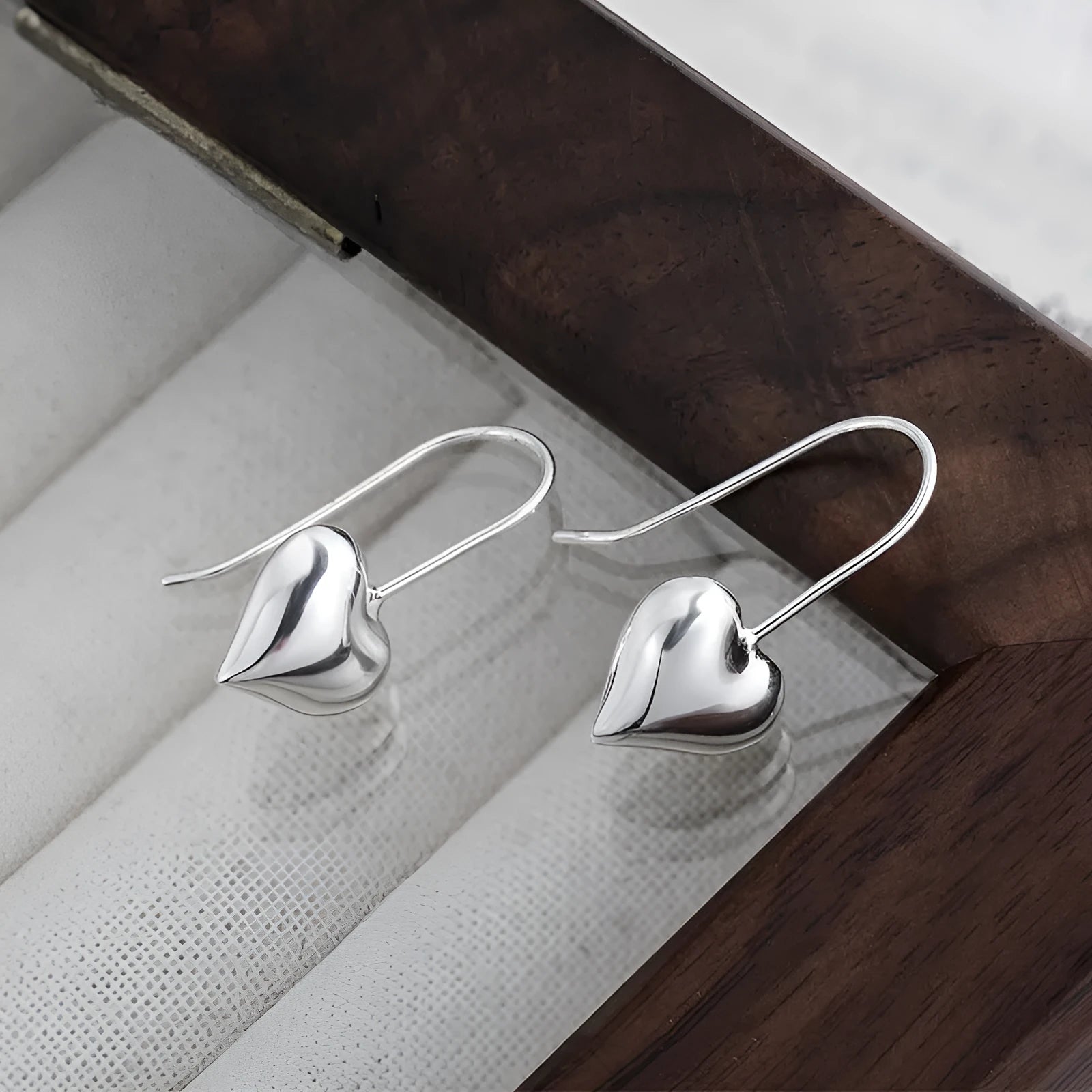 Silver heart-shaped earrings with three-dimensional glossy finish and Korean style design