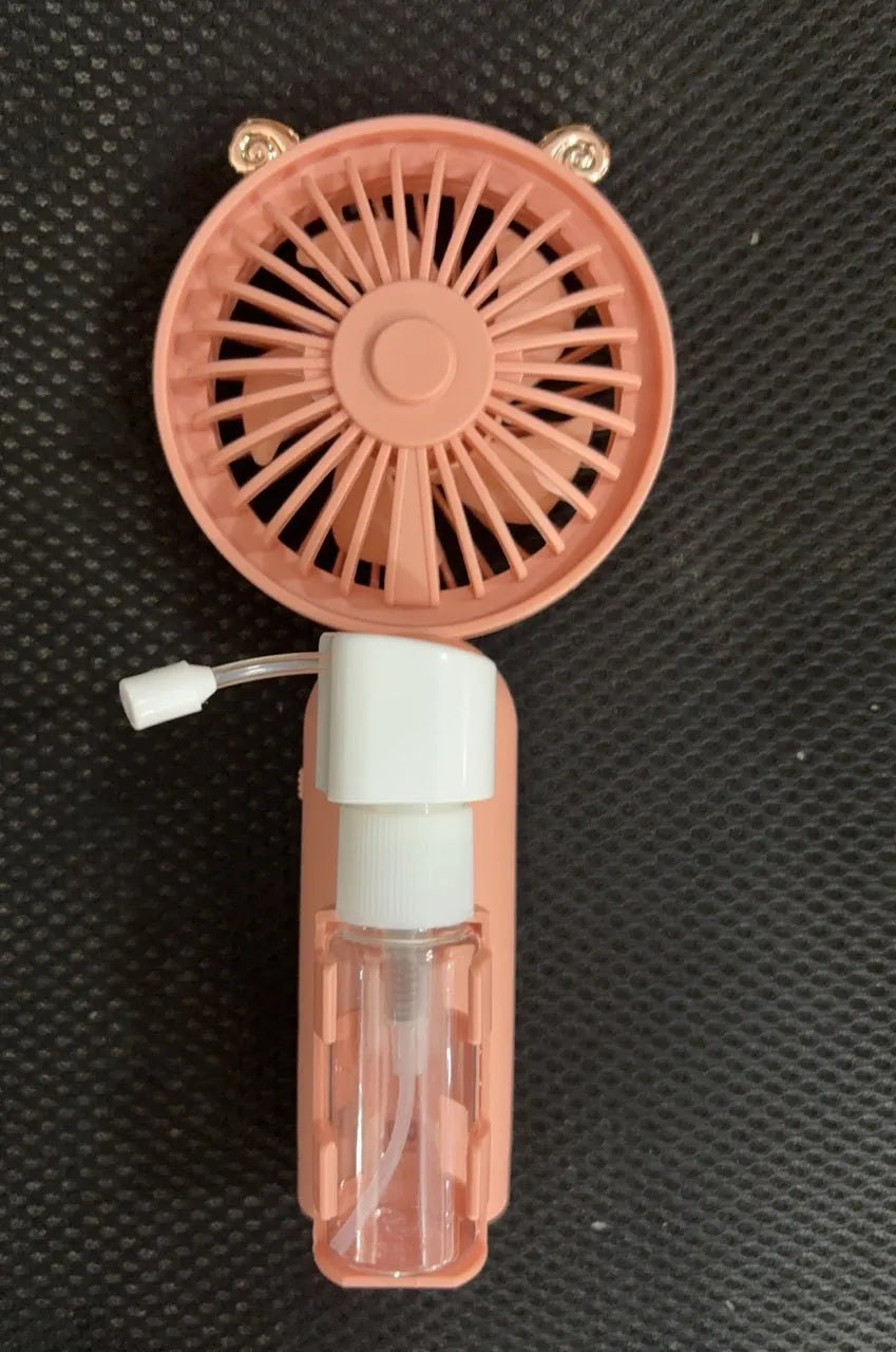 Plastic USB desk fan with a flexible nozzle in apricot colour on a wooden desk.