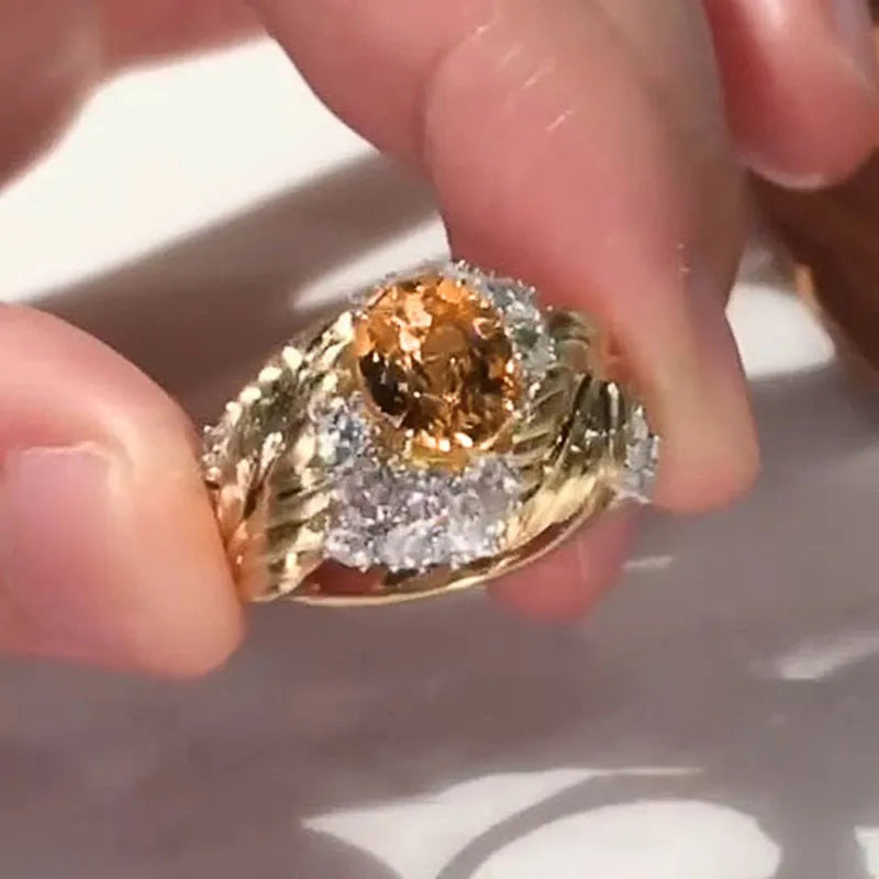 Gold-coloured embossed feather ring with geometric pattern and yellow zircon stone