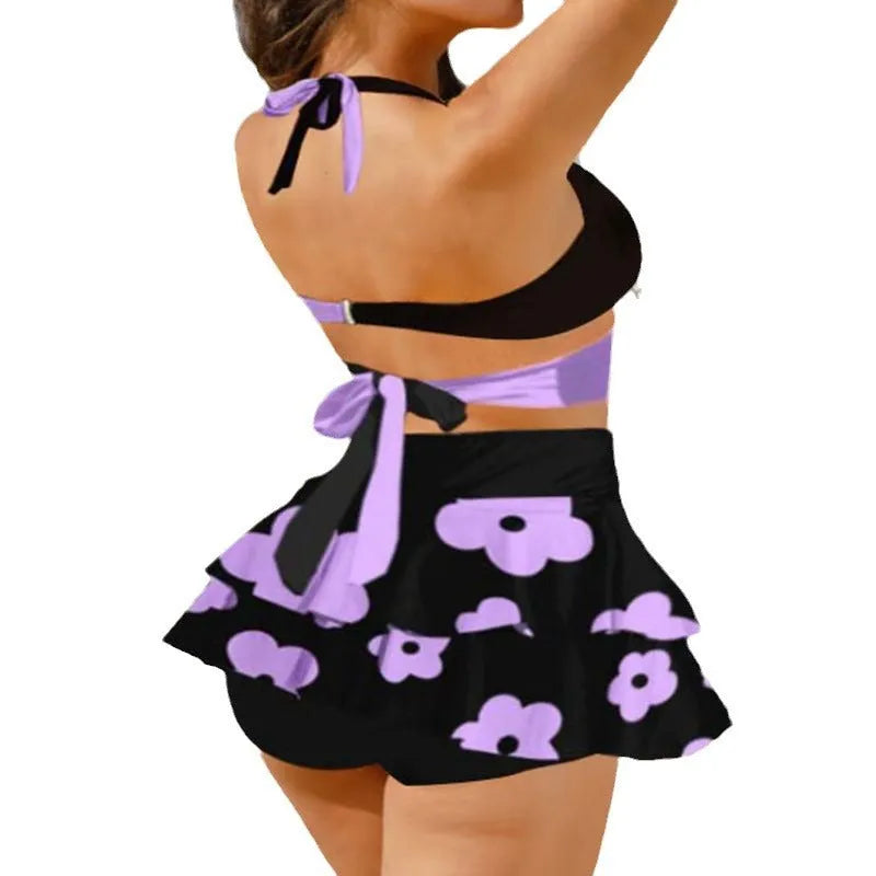 Women's purple split swimsuit bikini set with matching skirt and lace-up detailing