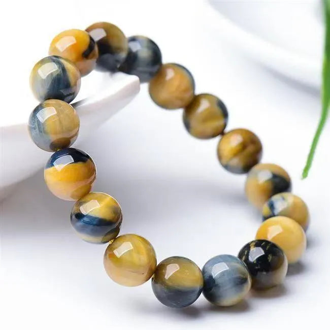Fantasy tiger eye agate stone bracelet with round beads in geometric pattern on wrist.