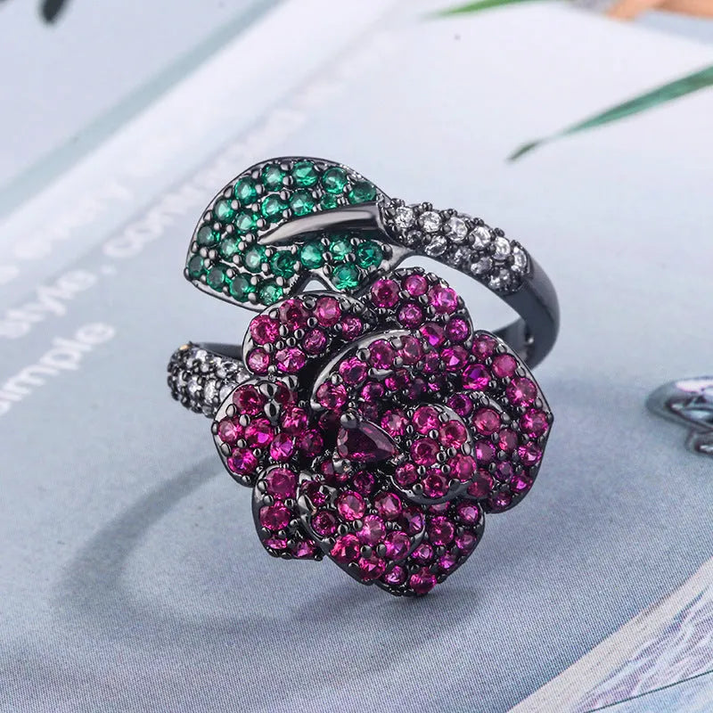 Geometric black gold flower ring with simulation red corundum centrepiece on female hand