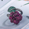Geometric black gold flower ring with simulation red corundum centrepiece on female hand