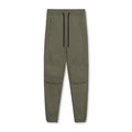 Men's loose grey fitness trousers with ankle ties on a gym floor.