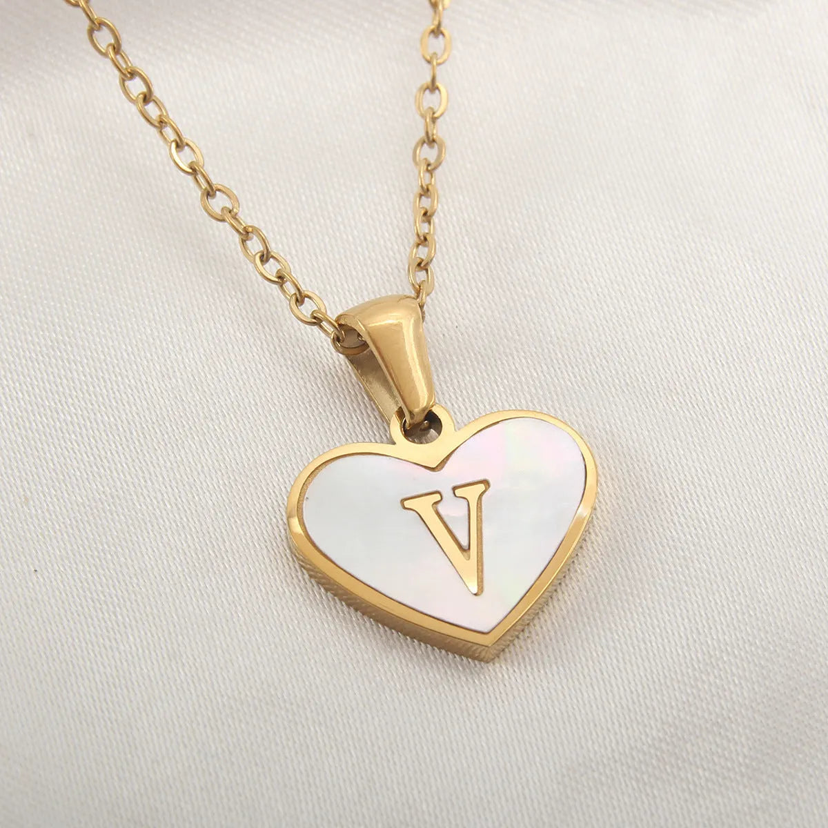 Gold plated heart-shaped necklace with white shell pendant on adjustable stainless steel chain