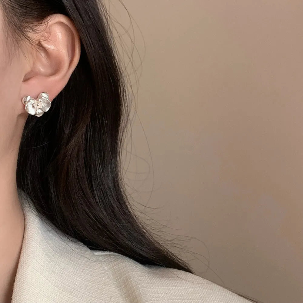 Retro flower earrings in gold or silver with detailed petal design on copper base