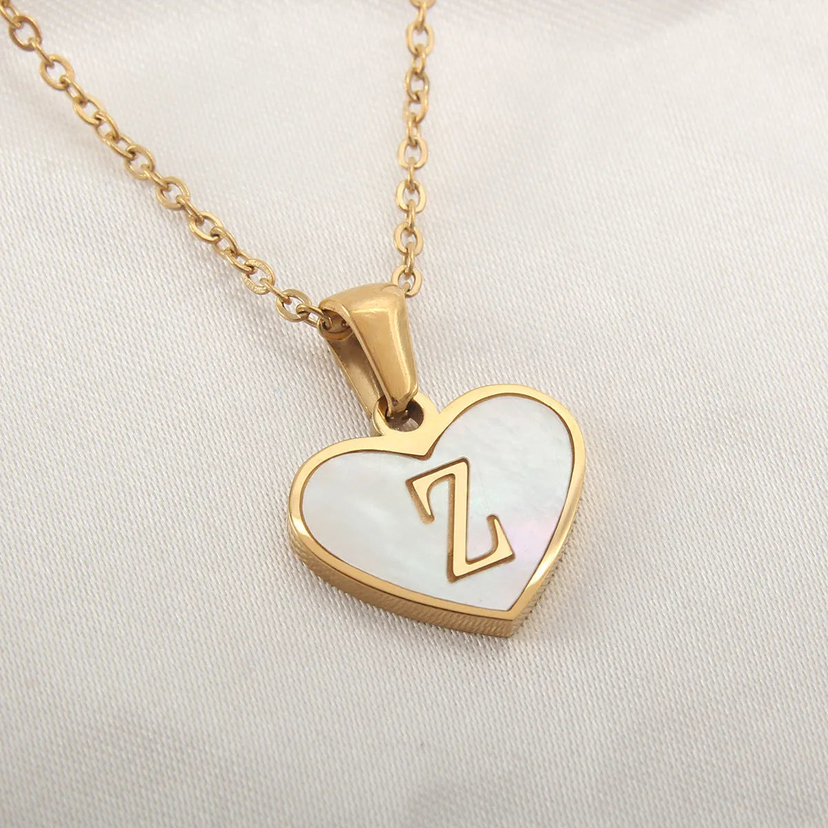 Gold plated heart-shaped necklace with white shell pendant on adjustable stainless steel chain