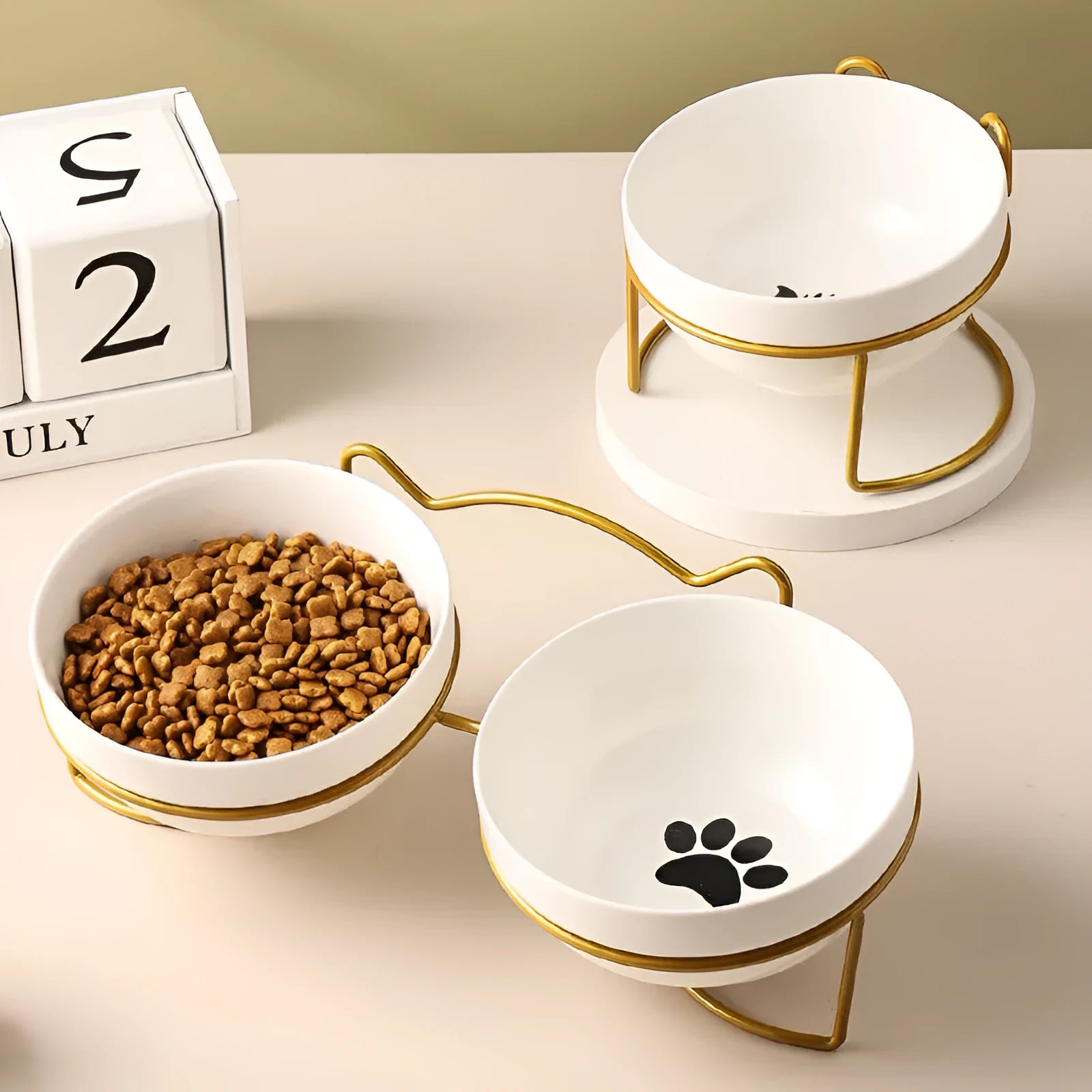 White ceramic pet bowl with cat paw print pattern in black iron frame stand