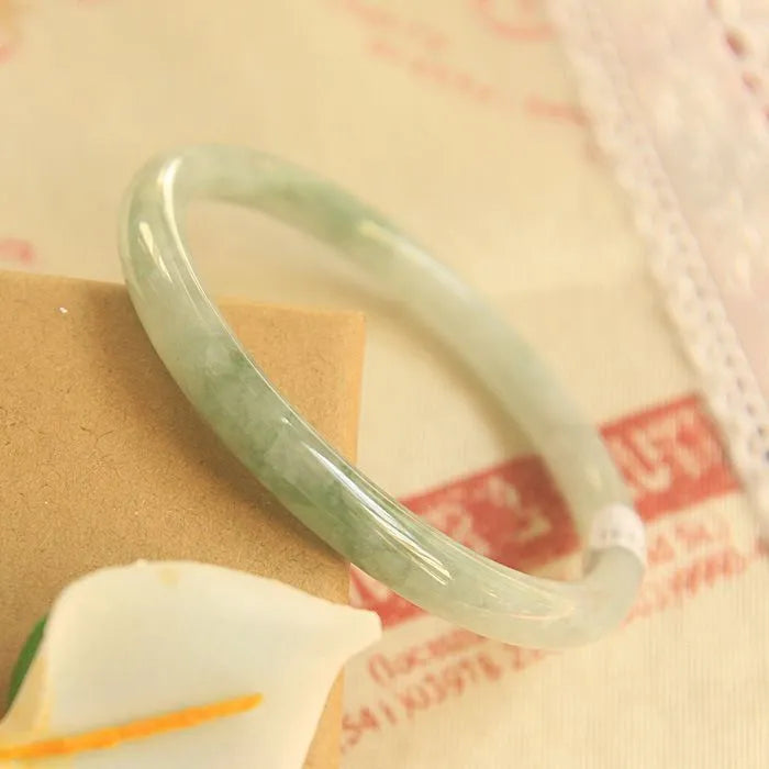 Green jade waxy geometric bracelet with Chinese styling on wrist