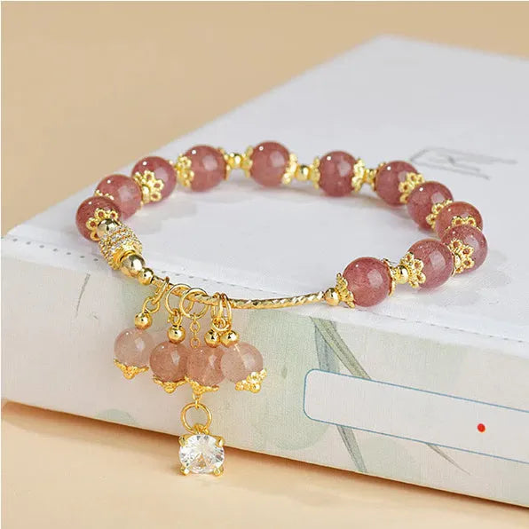 Women's pink strawberry quartz crystal bracelet with heart-shaped charms and pearl decorative elements