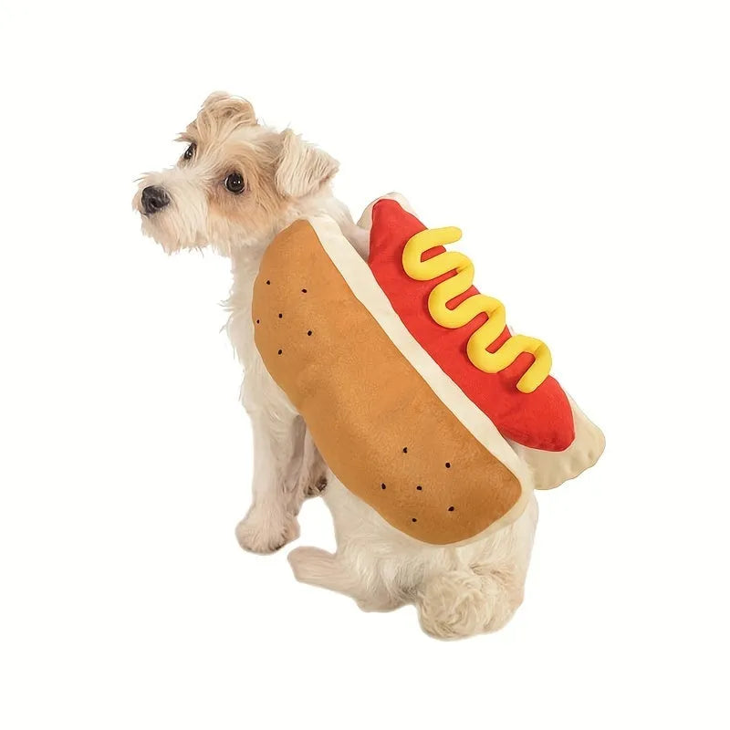 A small dog wearing a plush red and brown hot dog costume suit with mustard detailing.