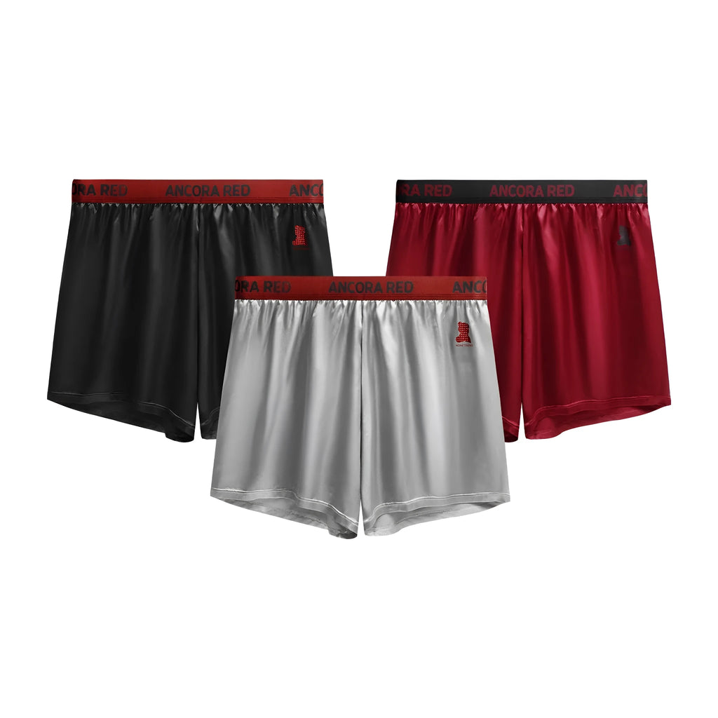 Men's solid colour knitted polyester boxer briefs on a mid-waist model, showing colour options black, blue, red, silver, purple, and brown.