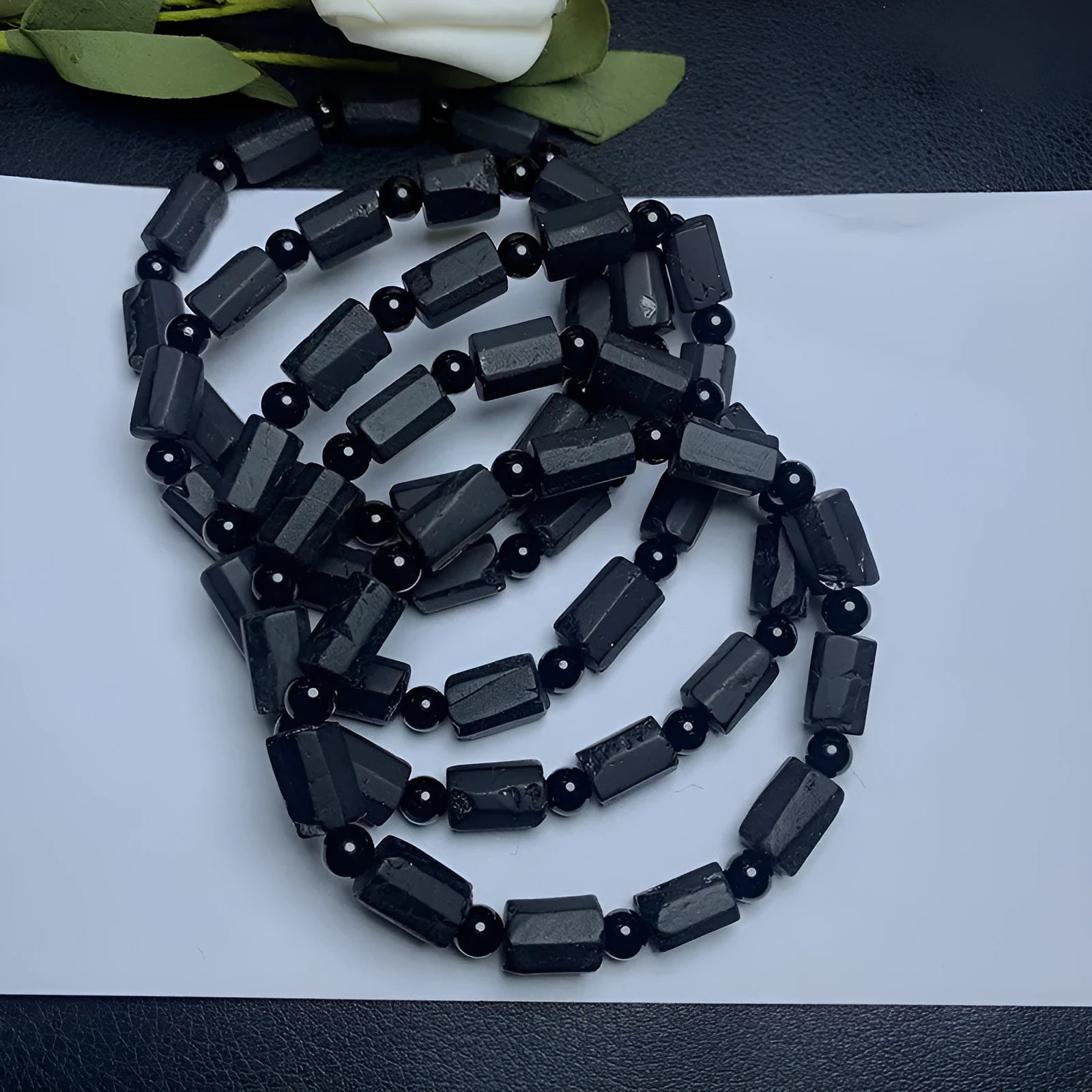 Black tourmaline rough stone bracelet with unpolished beads on a wrist.