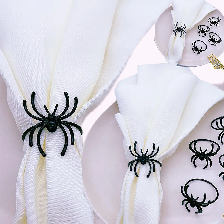 Set of six black alloy napkin rings with spider design for Halloween table decoration.