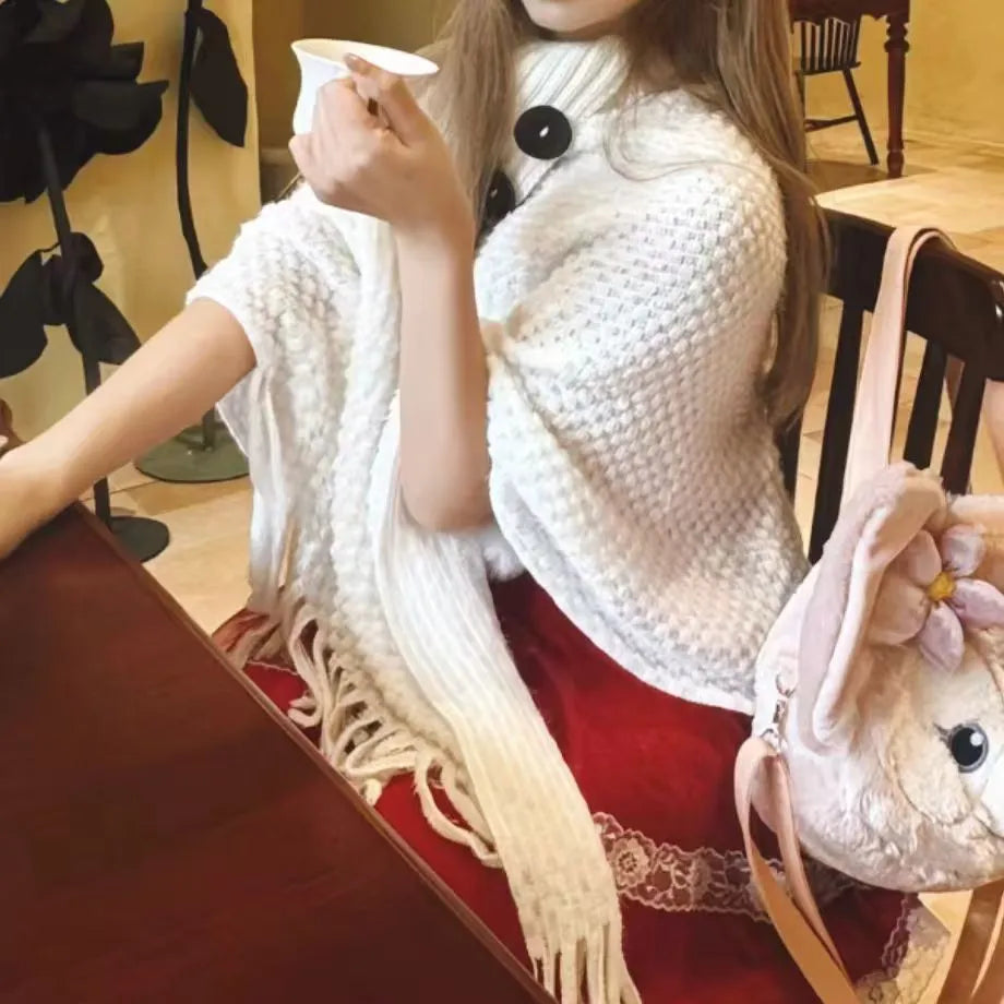 Women's triangular plush shawl cape with tassels in a cashmere and acrylic blend fabric.