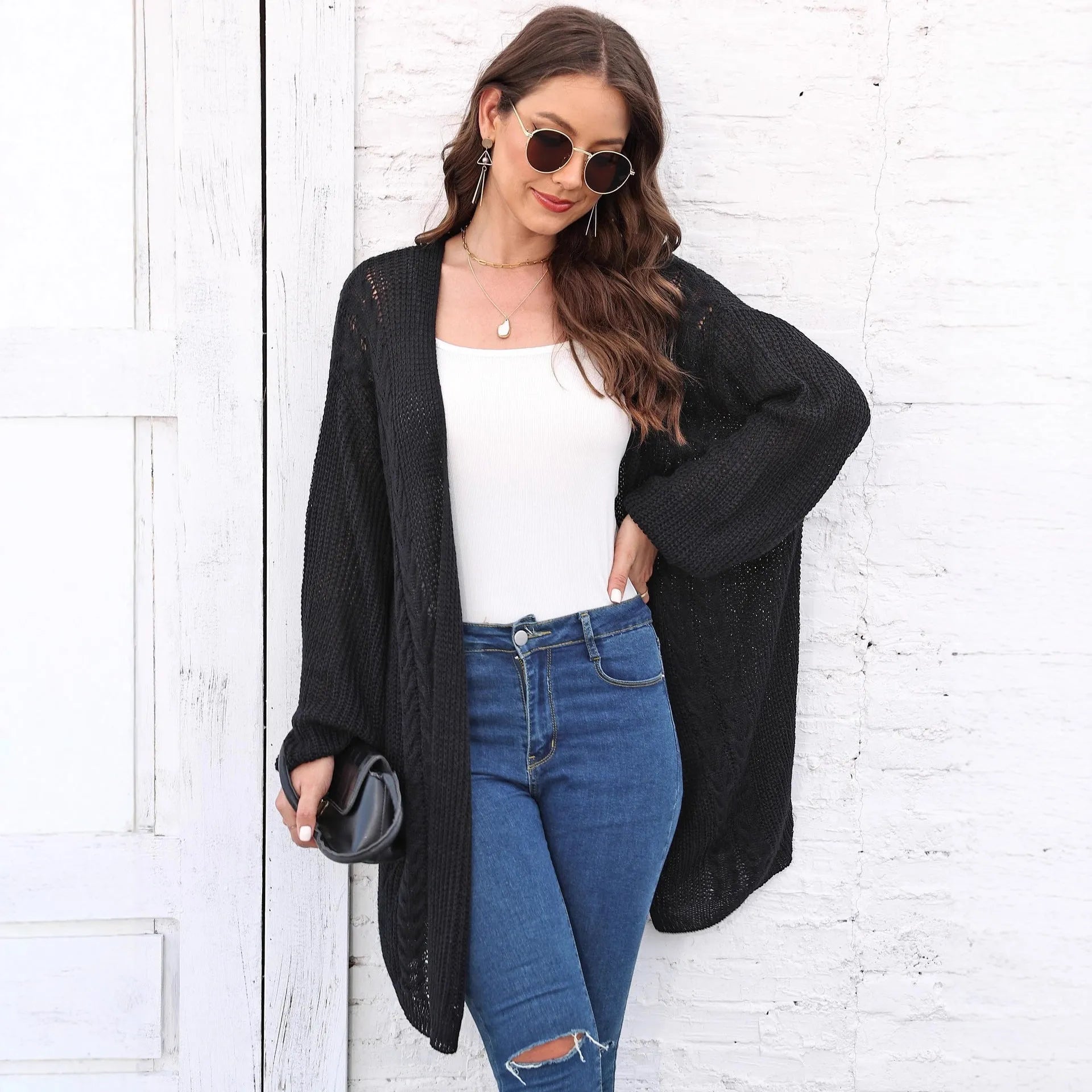 Women's loose brown acrylic sweater coat hanging on a hanger