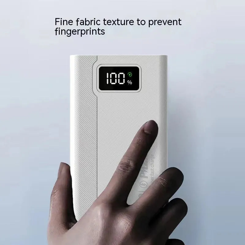 Large capacity black and white plastic power bank showing size relative to a smartphone.