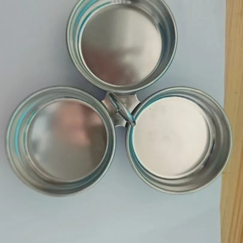 Compact stainless steel heart-shaped electric egg steamer on a kitchen counter.