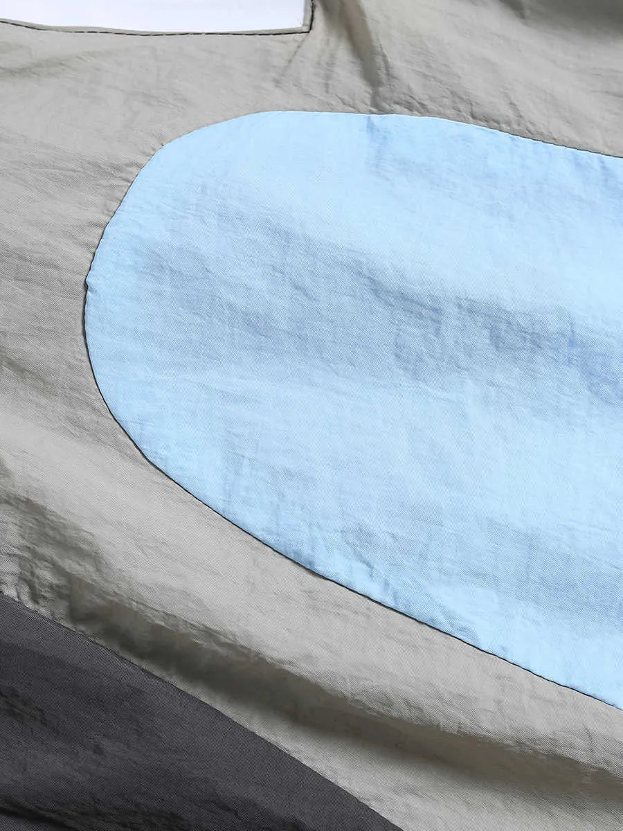 Blue men's patchwork loose-fit quick-drying shorts laid flat, showing straight-leg cut and tether fly.