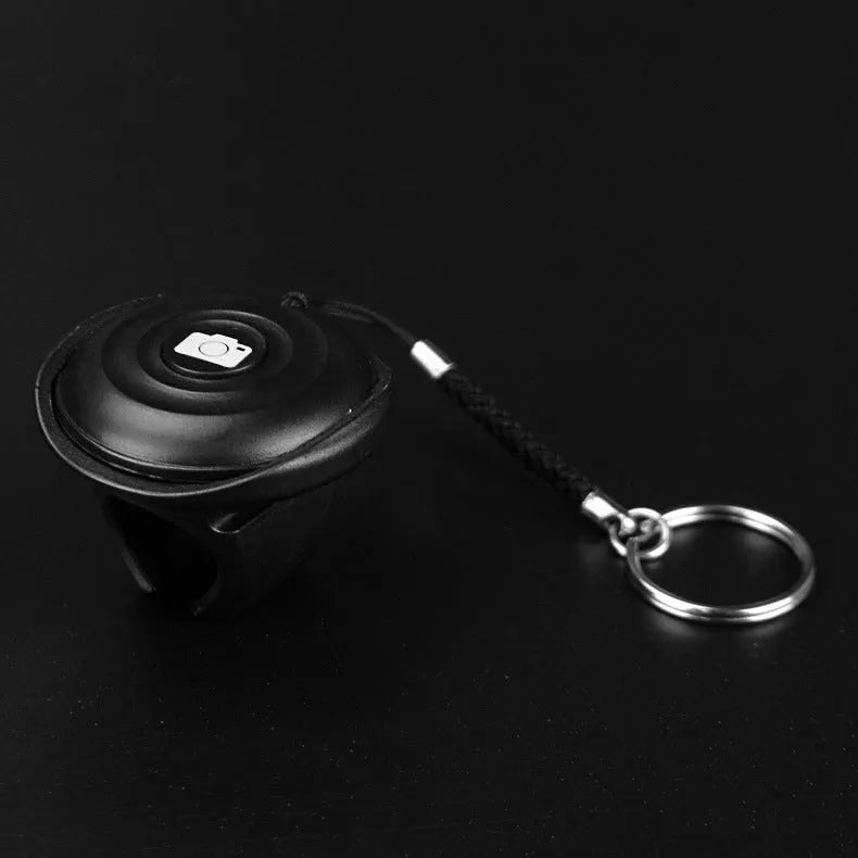 Black snap-on Bluetooth remote control for wireless smartphone camera shutter.