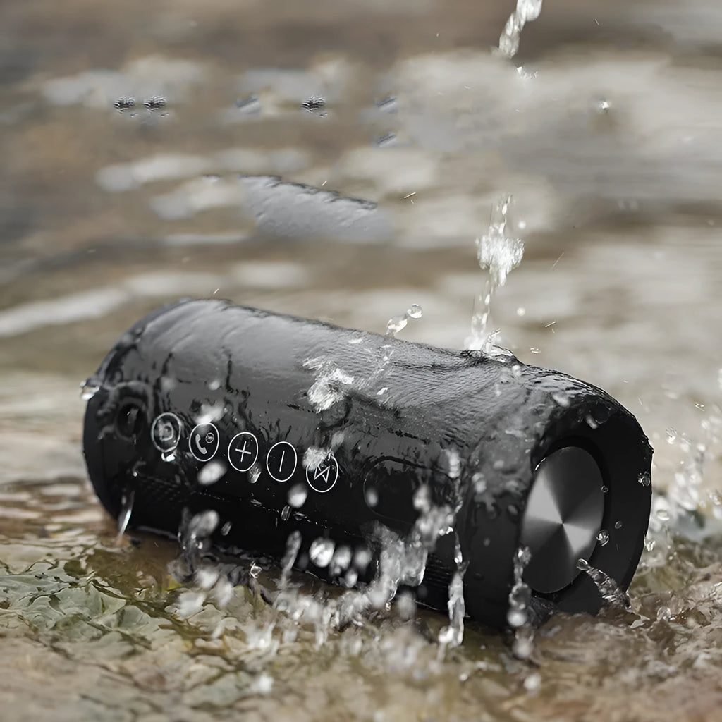 Black waterproof portable outdoor Bluetooth speaker with control buttons on top.