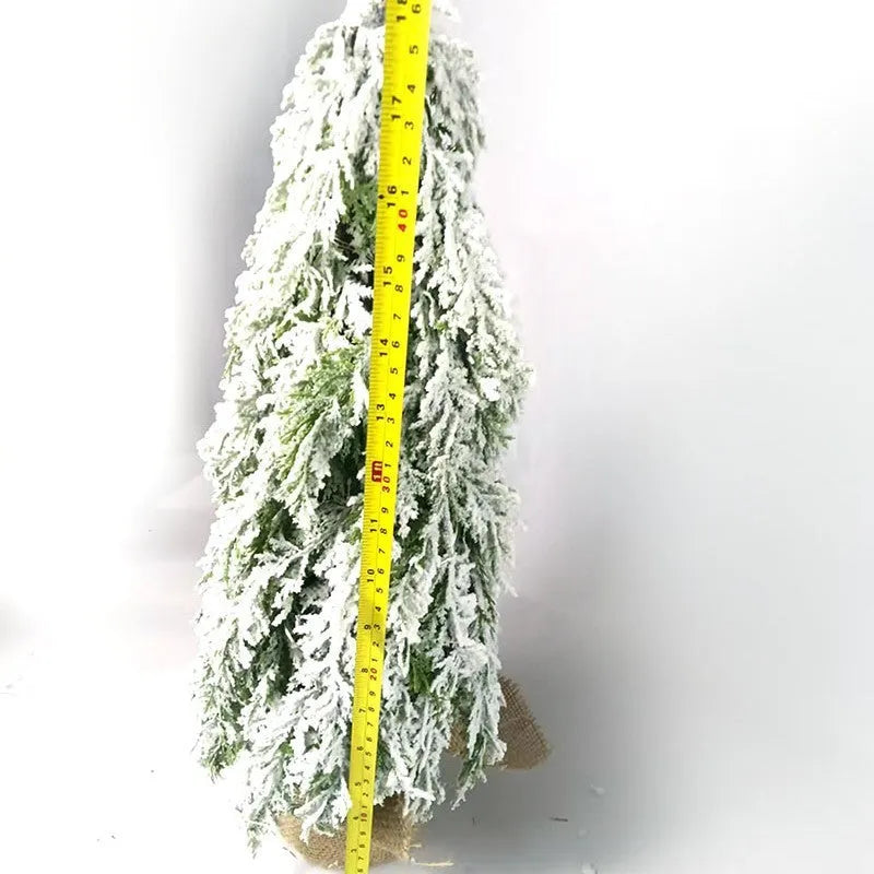 Small 24-inch white artificial Christmas tree with LED lights and snow spray on plastic branches