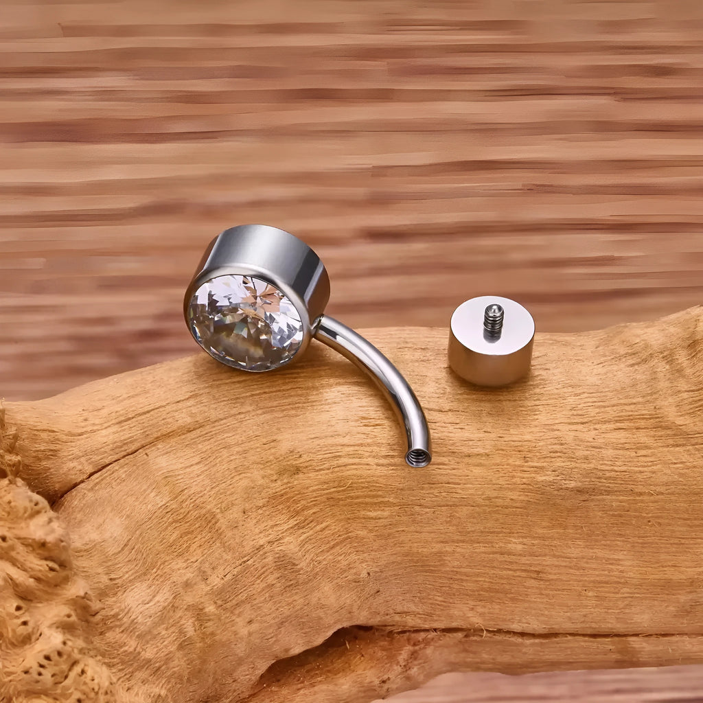 Double-headed zircon titanium alloy navel stud body jewellery on a white background.