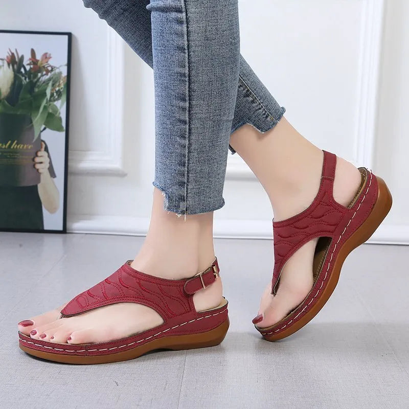 Women's wedge heel flip flop sandals with an adjustable buckle back strap in black.