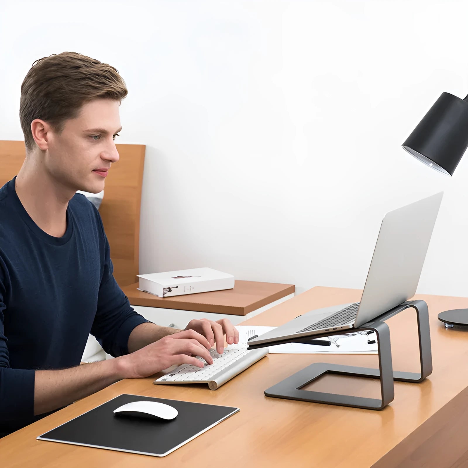 Black aluminium alloy laptop stand on desk with laptop elevated for cooling