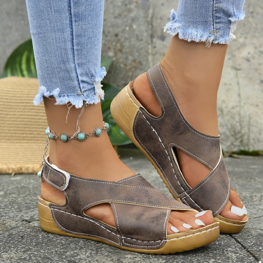 Women's brown platform Roman sandals with Velcro strap and open toe on a rubber sole.