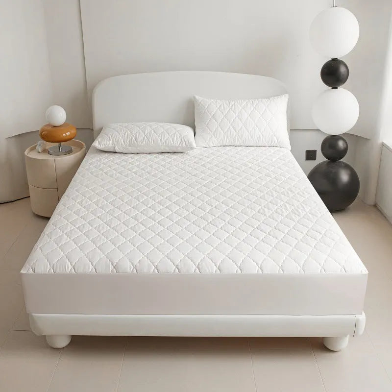 Diamond lattice quilted waterproof mattress protector in bamboo fibre shown on bed