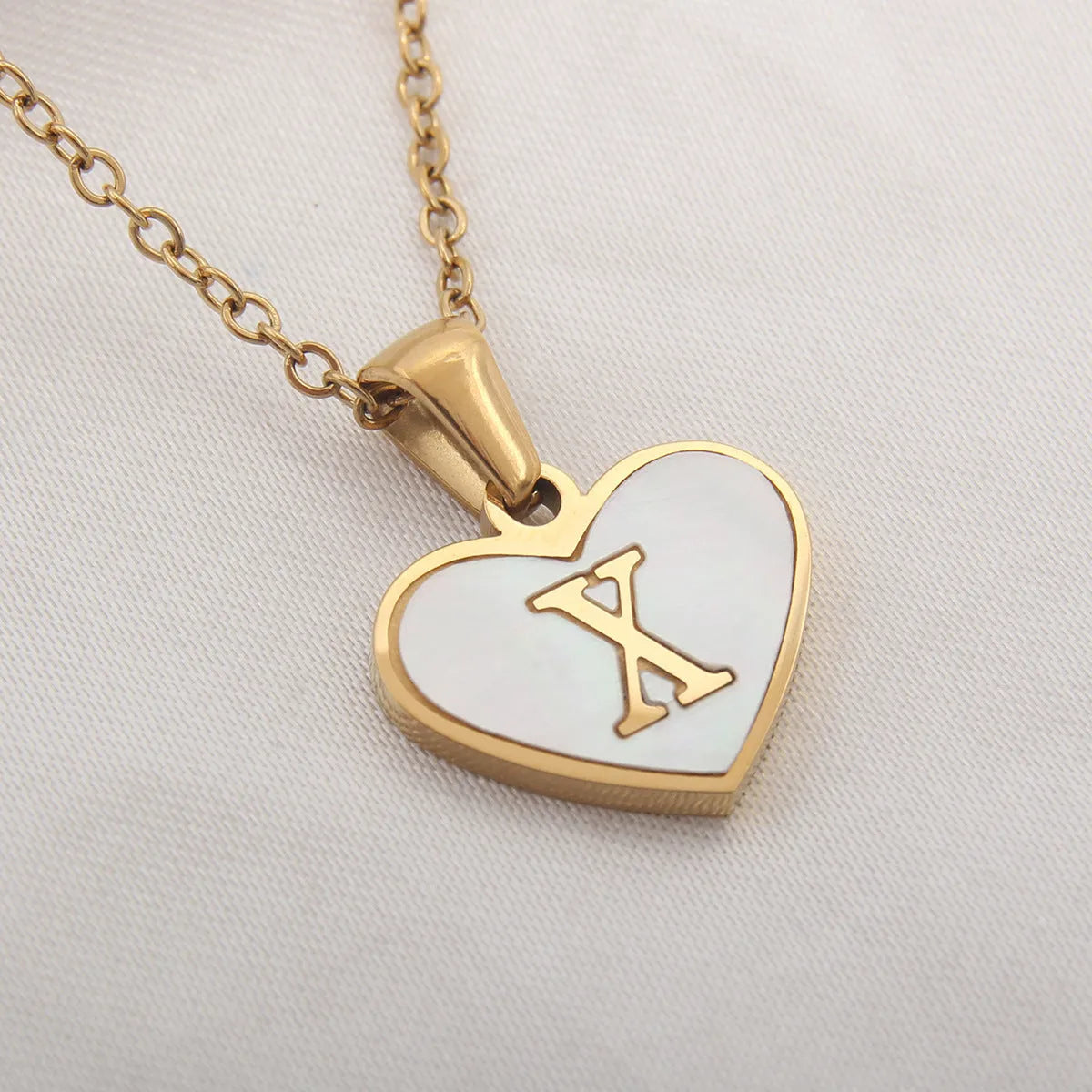 Gold plated heart-shaped necklace with white shell pendant on adjustable stainless steel chain