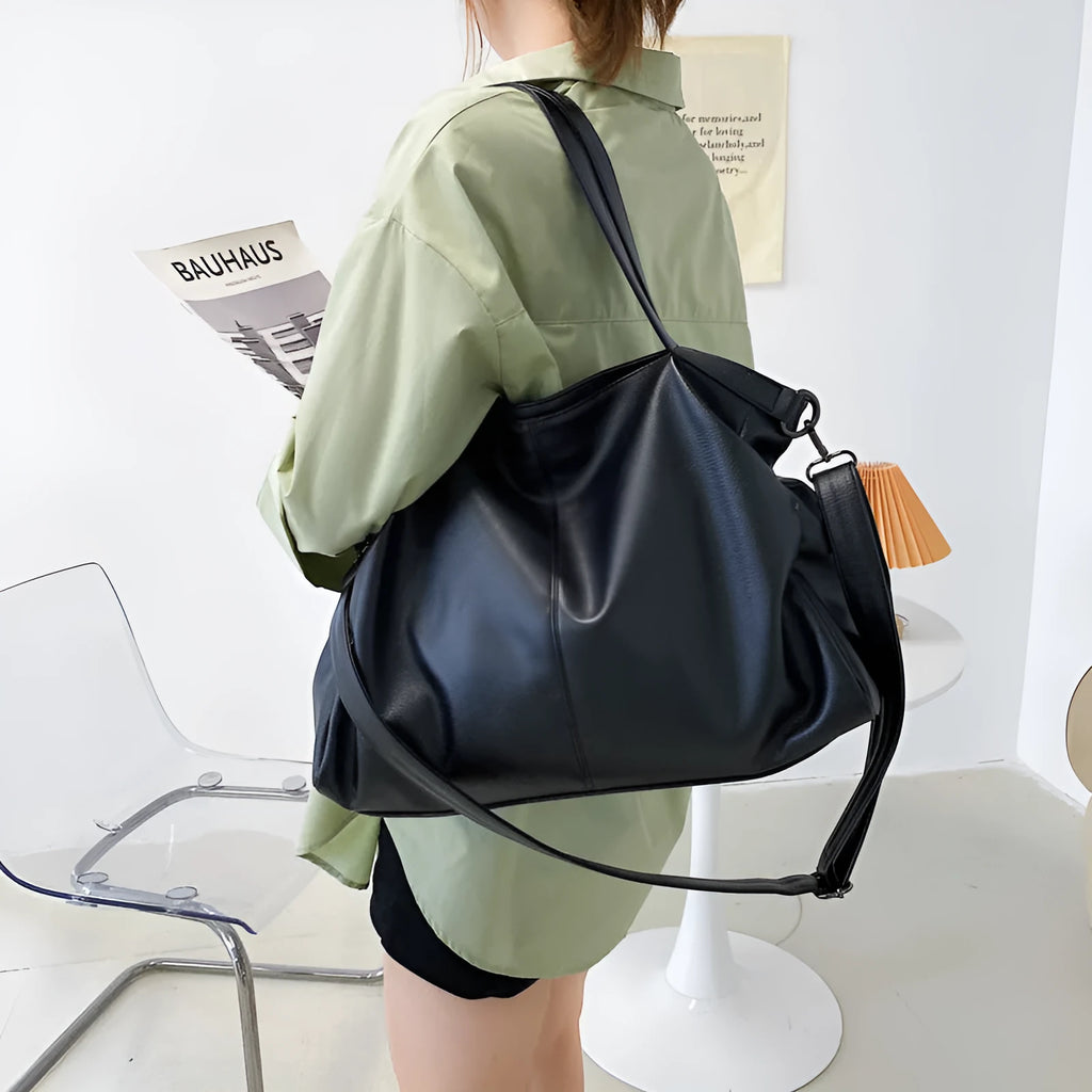 Large soft surface black messenger bag with a shoulder strap and zipper opening.