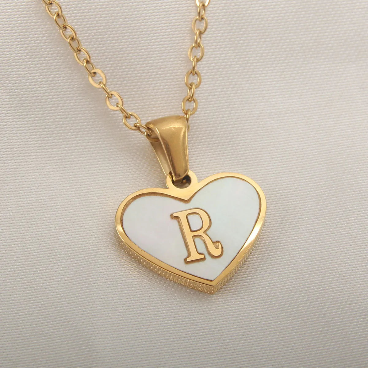 Gold plated heart-shaped necklace with white shell pendant on adjustable stainless steel chain
