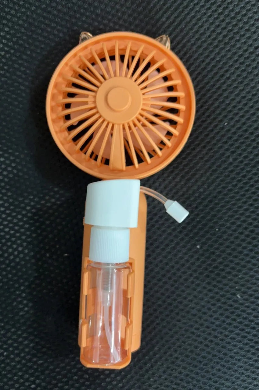 Plastic USB desk fan with a flexible nozzle in apricot colour on a wooden desk.