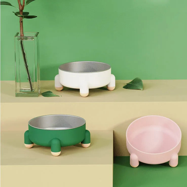 Green stainless steel pet bowl with non-slip base and high foot on a kitchen floor