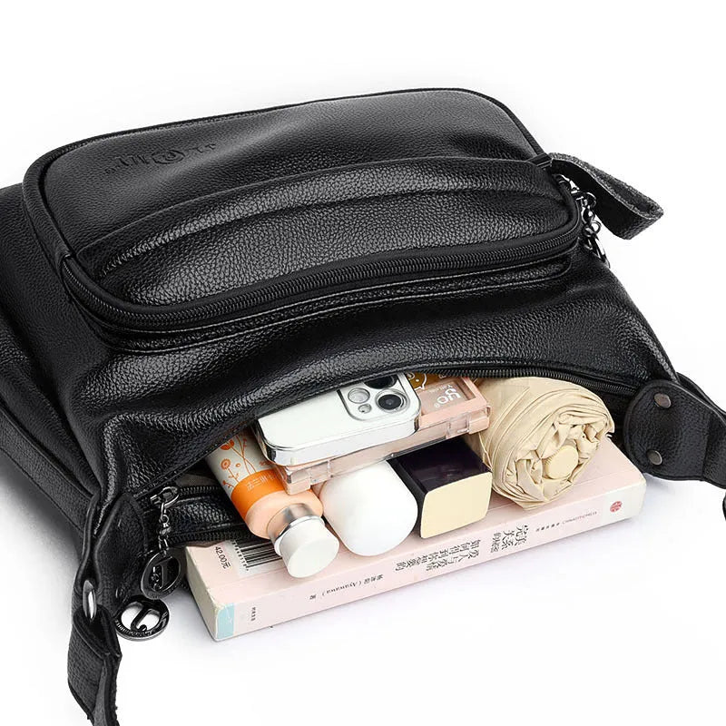 Large black PU shoulder bag with multiple internal compartments showing phone and document sections