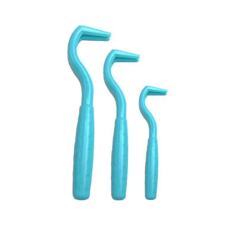 Set of three coloured plastic tick removal hooks for pets on a white background.