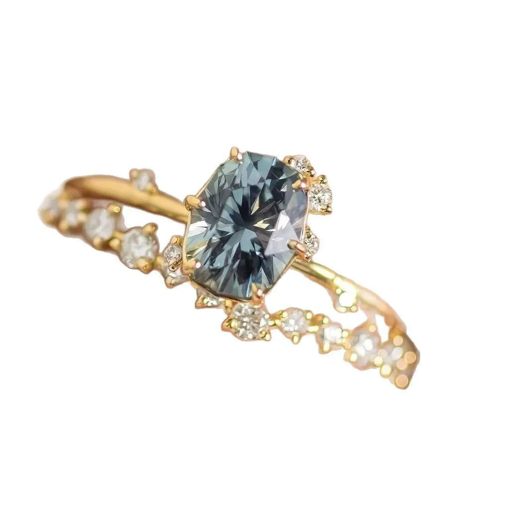 Gold electroplated alloy flower-shaped ring with inlaid green zircon stones on a white background.