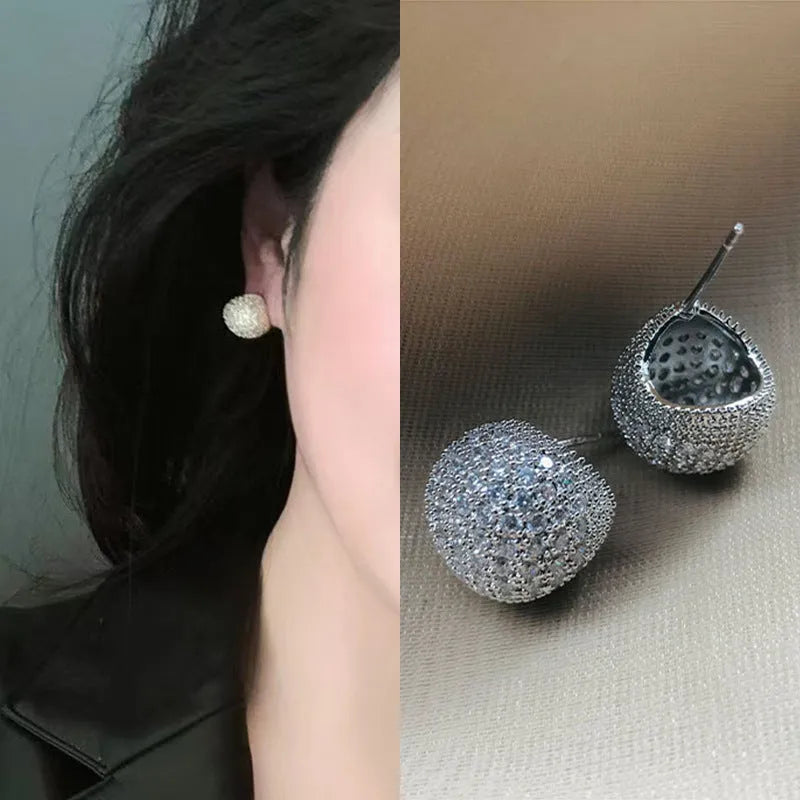 Geometric drop-shaped clip earrings with sphere elements and diamond flashing in gold or white colour